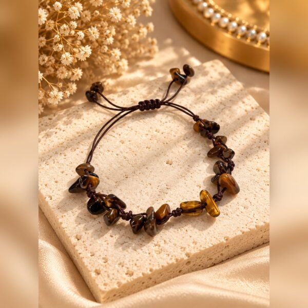 Bracelet MELLIA en éclats d’œil de tigre sur cordon marron, posé sur pierre claire – Serinaé
