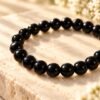 Détail des perles rondes d’obsidienne noire à la finition polie et brillante du bracelet NÉRA Noir Intense