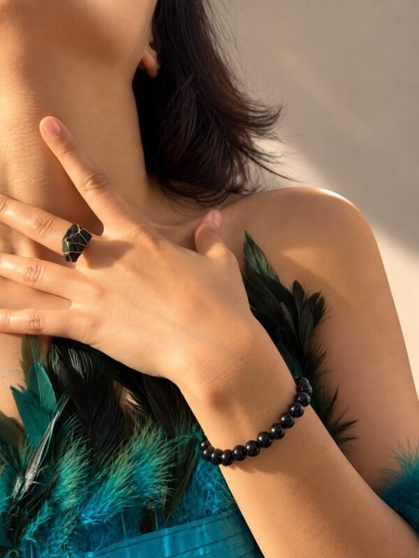 Bracelet NÉRA Noir Intense porté au poignet, perles rondes d’obsidienne noire brillantes