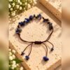 Bracelet en éclats de sodalite sur cordon marron ajustable, posé sur une pierre
