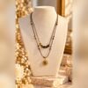 collier solea oeil de tigre soleil buste Collier SOLÉA double rang sur cordon marron, perles d'œil de tigre et pendentif soleil aux finitions dorées, porté sur buste crème – Serinaé