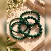 lot-4-bracelets-malya-malachite Lot de quatre bracelets MALYA en malachite naturelle posés sur un bloc de pierre