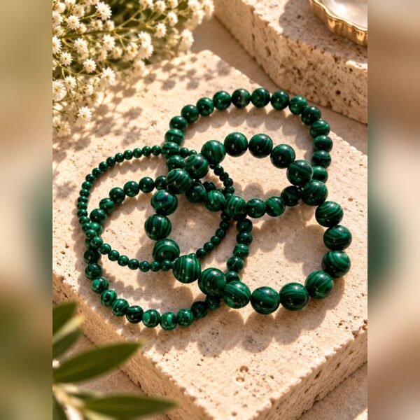 lot-4-bracelets-malya-malachite Lot de quatre bracelets MALYA en malachite naturelle posés sur un bloc de pierre