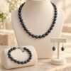 Parure ÉPURE Noire – perles d'eau douce noires 1 Parure ÉPURE Noire SERINAÉ : collier, bracelet et boucles d'oreilles en perles de culture d'eau douce noires sur buste de présentation