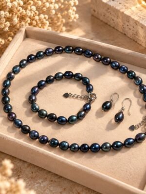 Parure ÉPURE Noire – perles d'eau douce noires 2 Parure ÉPURE Noire en perles d'eau douce noires aux reflets bleutés présentée dans un plateau