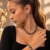 Parure ÉPURE Noire – perles d'eau douce noires 4 Parure ÉPURE Noire portée : collier et bracelet en perles d'eau douce noires aux reflets irisés