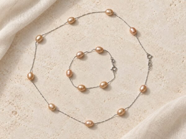 Collier et bracelet ÉPURE en perles d'eau douce rose pêche sur fine chaîne en argent Sterling 925, posés sur une pierre