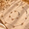 Collier et bracelet ÉPURE en perles d'eau douce rose pêche clair et argent 925 sur une pierre, lumière dorée