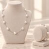 Parure ÉPURE blanche : collier et bracelet en perles d'eau douce blanches sur chaîne en argent Sterling 925, présentés sur buste et support