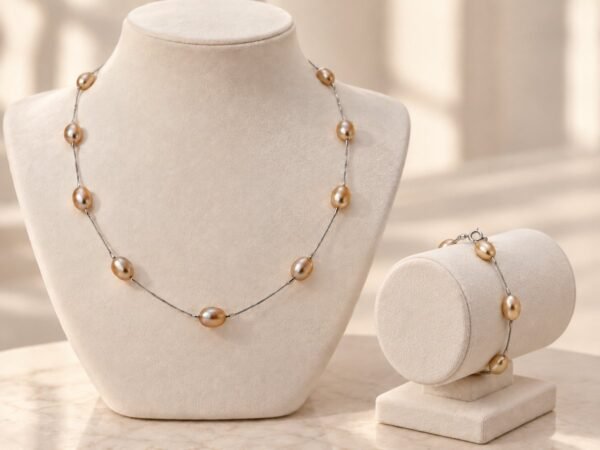 Parure ÉPURE rose pêche : collier et bracelet en perles d'eau douce sur chaîne en argent Sterling 925, présentés sur buste et support